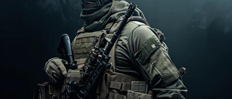 A soldier in full tactical gear, armed with an assault rifle, stands in a dark room. photo