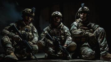 Three soldiers in full combat gear kneeling in a dark room photo