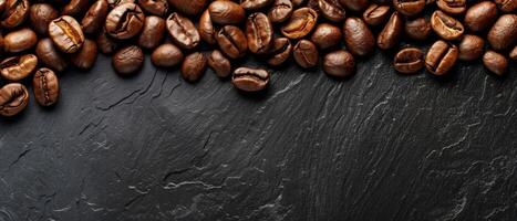 Coffee beans scattered on a dark stone background. photo