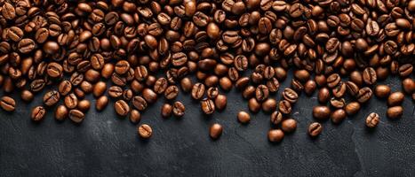 A close up of a pile of roasted coffee beans on a dark background. photo