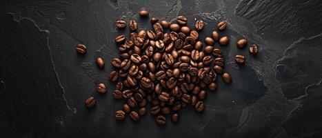 Coffee beans scattered on a dark stone background. Top view. photo