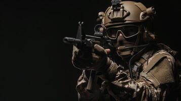 A soldier in full combat gear is aiming his rifle. photo