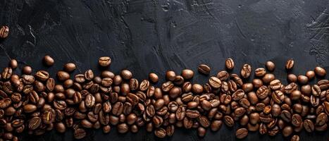 scattered coffee beans on a black stone background photo