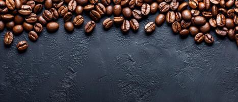 Coffee beans scattered on a dark stone background. Top view with copy space. photo