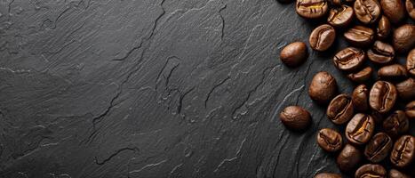 Coffee beans scattered on a dark stone background. photo