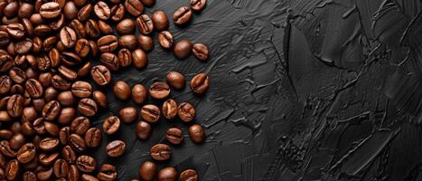 Coffee beans scattered on a black stone background. Top view. photo