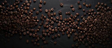 scattered coffee beans on a black stone background photo