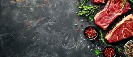 Raw fresh beef steak with spices and herbs on a black stone background. photo