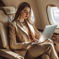 A young businesswoman is working on her laptop while flying on a private jet photo
