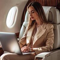 Thoughtful businesswoman using laptop while sitting in private jet. photo