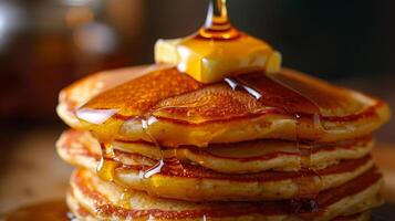 A close-up of a stack of golden brown pancakes dripping with maple syrup and topped with a pat of melting butter, photography photo