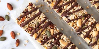 Keto granola bar filled with nuts, seeds, and a drizzle of sugar-free chocolate, picture photo