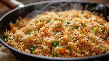 Large skillet filled with golden crispy fried rice mixed with vegetables and soy sauce steaming hot and ready to serve, photography photo