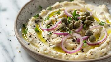Plate of fava bean dip garnished with sliced red onions capers and a drizzle of extra virgin olive oil, photorealistic photo