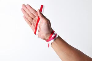 Hands spread with a red and white ribbon photo