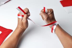 Hands clasped enthusiastically with a red and white ribbon wrapped photo