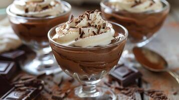 Rich and creamy chocolate mousse served in elegant glass cups topped with whipped cream and chocolate shavings, photo