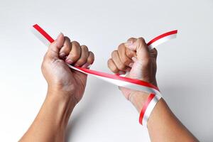 Hands clasped enthusiastically with a red and white ribbon wrapped photo
