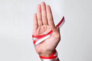 Hands spread with a red and white ribbon which is the Indonesian flag photo