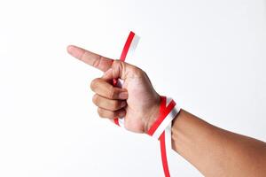 Human hand pointing with index finger with red and white ribbon photo
