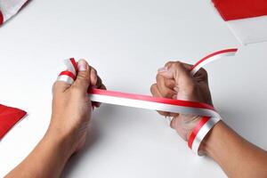 Hands clasped enthusiastically with a red and white ribbon wrapped photo