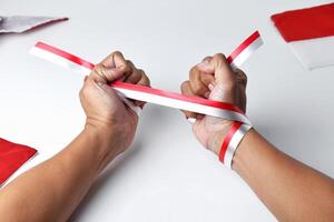 Hands clasped enthusiastically with a red and white ribbon wrapped photo