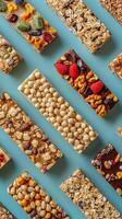 Various healthy protein snack bars on turquoise background, top view, photo