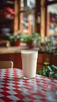 White milk carton mockup on red and white checkered counter with plants, photo