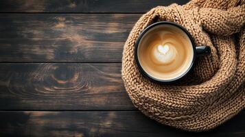 Cozy scene with a coffee cup and a knitted scarf on a rustic table photo