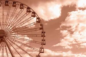 Big round Ferris wheel on background of sky with clouds. Natural Mocha brown background with copy space. Concept of growth. Demonstrating color of 2025 year photo