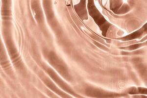 Textured background of waves on Mocha brown water with solar lightning. Concept of peace and relaxation. Close-up, selective focusing, defocusing. Demonstrating color of 2025 year photo