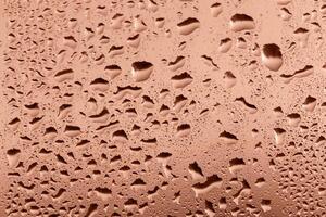 Drops on glass in sunset glow close up. Perfect Mocha brown background for your design and inspiration. Selective focus, defocus. Demonstrating color of 2025 year photo