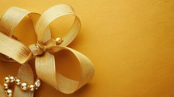 Golden ribbon and pearls on a yellow background photo