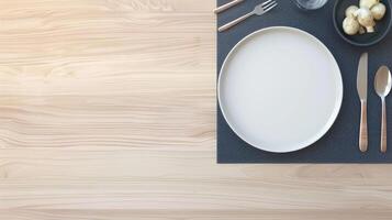 A plate with a knife and fork on a wooden table photo