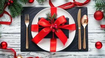 Christmas table setting with red ribbon and gold fork photo