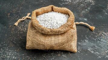 White rice in a sack on a dark background photo