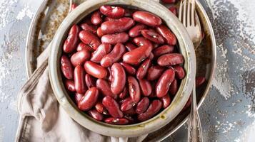 A bowl filled with red beans on a wooden table photo