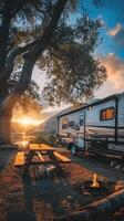 A rv is parked near a lake at sunset photo