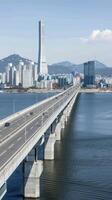 A bridge spanning over the water with a city in the background photo
