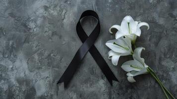 Black ribbon and white lily on concrete background photo