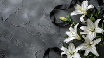 White lilies and black ribbon on a gray background photo