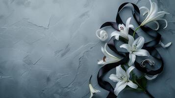 White lilies and black ribbon on a gray background photo