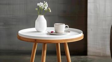 A white table with a vase and coffee cup on it photo