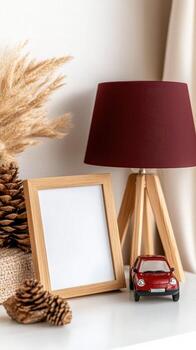 A red car and a lamp on a table next to a frame photo