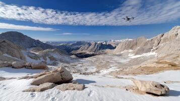 A drone flying over a mountain range with snow photo