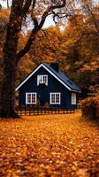 A blue house surrounded by autumn leaves photo