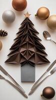 A table setting with a christmas tree and silverware photo