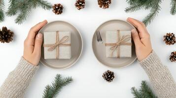 Two hands holding two plates with wrapped presents on them photo