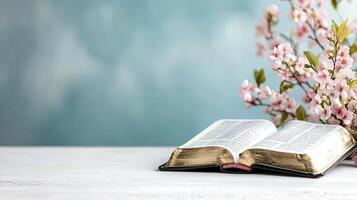 Bible and cherry blossom on white table photo