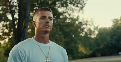 A man in a white shirt and a necklace photo
